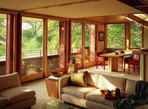 View of living room with windows overlooking scenic Wisconsin landscape and sliding glass doors leading out to patio.