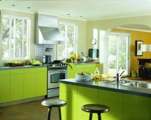 Vibrant kitchen with lime green cabinets, mustard-colored walls, and white-frame sliding windows.