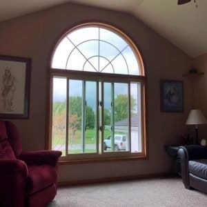 View of the interior of a home with a specialty shaped window overlooking the neighborhood.