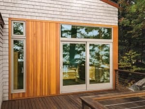 Outdoor patio with wood decking and modern sliding patio doors with sidelite over top.