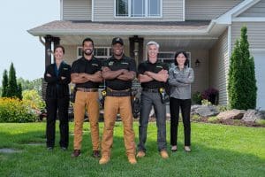 Team of RBA installers posing for photo in front of luxurious home