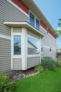 Bay Windows Wausau WI Exterior view of residence featuring beige house siding, lush lawn, and a bay window.