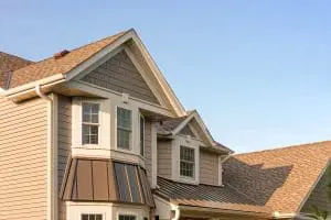 Large, two-story home outfitted with Andersen replacement windows. Blue skies in background.