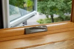 Close-up view of wood frame window overlooking suburban street.