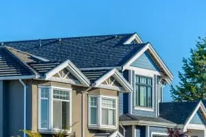 A perfect neighborhood. Houses in suburb at Summer in the north America. Fragment of a luxury house with nice window over blue sky.