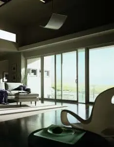 Warm living room with large sliding glass doors partially opened, leading to outdoor living space.