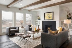 Living room in single family home with wood floors, white brick walls, and energy efficient picture windows.