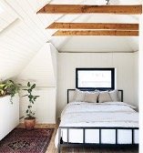 Bedroom with black window and vaulted ceilings
